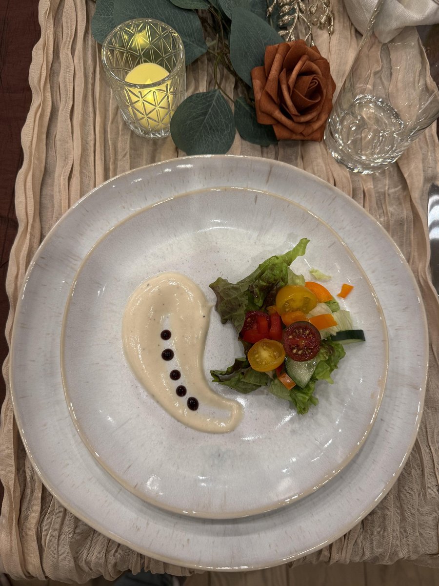Elegantly plated appetizer with cream sauce and fresh garden salad